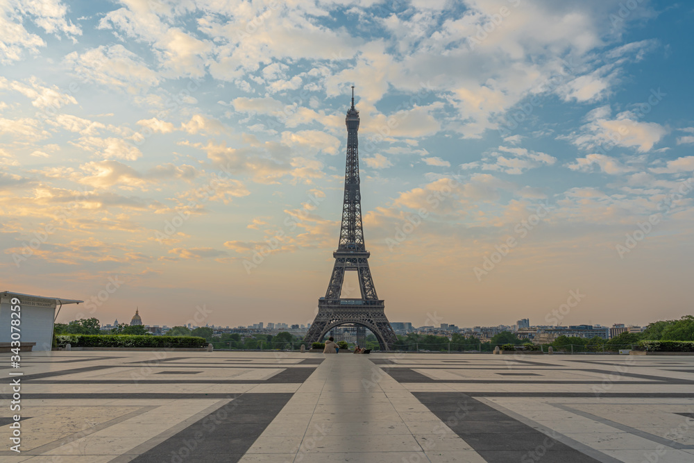Paris, France - 04 25 2020: View of the Eiffel Tower from the Trocadero esplanade with a seated couple during the coronavirus period