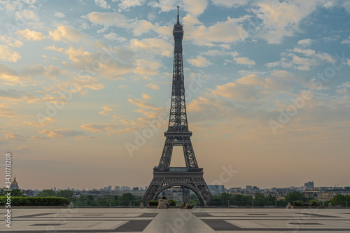 Paris, France - 04 25 2020: View of the Eiffel Tower from the Trocadero esplanade with a seated couple during the coronavirus period