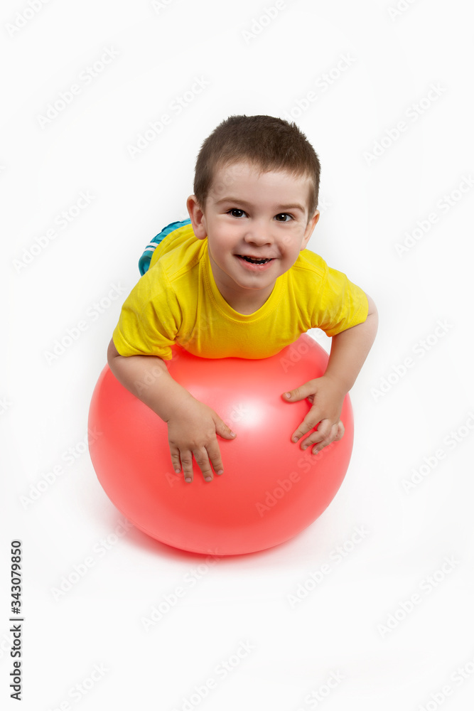the boy is engaged in fitness, sports with red ball the boy is engaged in fitness, sports with red ball