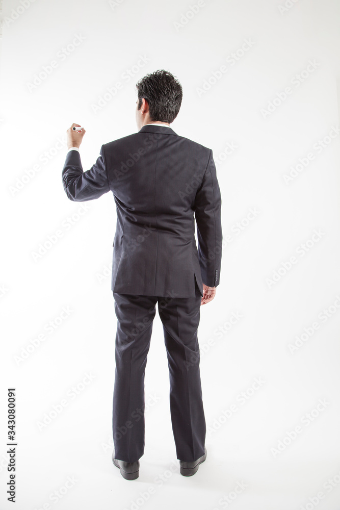 Business man wearing suit pretends to write on screen camera holding marker back view Business man wearing suit pretends to write on screen camera holding marker back view