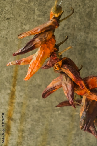 A bunch of dried red hot chili peppers on a gray wall background
