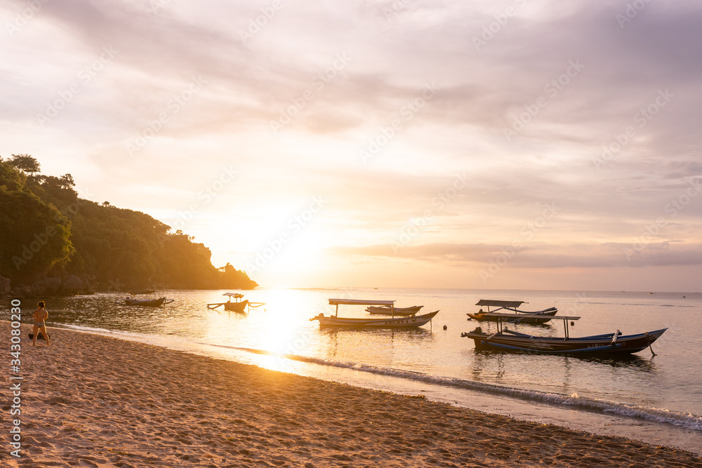 Beautiful deserted beach on the island of Bali at sunset. Rocks and nature. Plants and houses on the coast. Tropical paradise. Stones and white sand on the ocean Beautiful deserted beach on the island of Bali at sunset. Rocks and nature. Plants and houses on the coast. Tropical paradise. Stones and white sand on the ocean