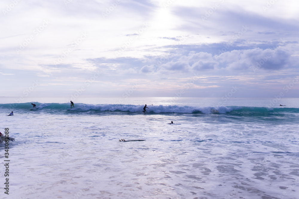 Surfing on the island of Bali in the Pacific and Indian Ocean. Male surfers engage in active sports on sick waves Surfing on the island of Bali in the Pacific and Indian Ocean. Male surfers engage in active sports on sick waves