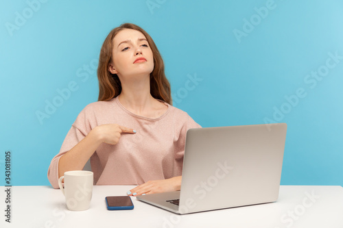 Tableau sur toile This is me! Egoistic selfish employee woman pointing herself and looking with arrogant self-confident expression, working on laptop from home office