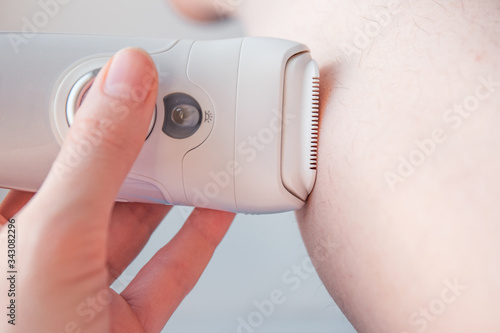 the process of hair removal of a female leg with an epilator at home. personal care concept. selective focus
