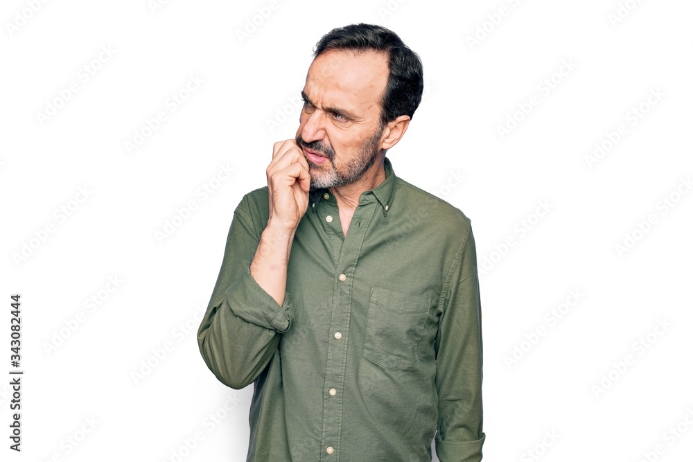 Middle age handsome man wearing casual green shirt over isolated white background thinking concentrated about doubt with finger on chin and looking up wondering Middle age handsome man wearing casual green shirt over isolated white background thinking concentrated about doubt with finger on chin and looking up wondering