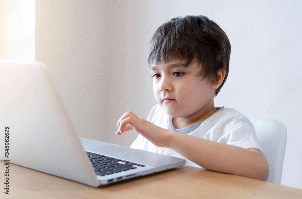 Kid self isolation using tablet for his homework,Child doing using digital tablet searching information on internet during covid 19 lock down,Home schooling,Social Distance,E-learning online education Kid self isolation using tablet for his homework,Child doing using digital tablet searching information on internet during covid 19 lock down,Home schooling,Social Distance,E-learning online education
