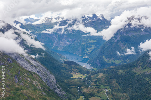 View to Geiranger fjord and eagle road surrounded by clouds from Dalsnibba mountain  serpentine road  Norway  selective focus.