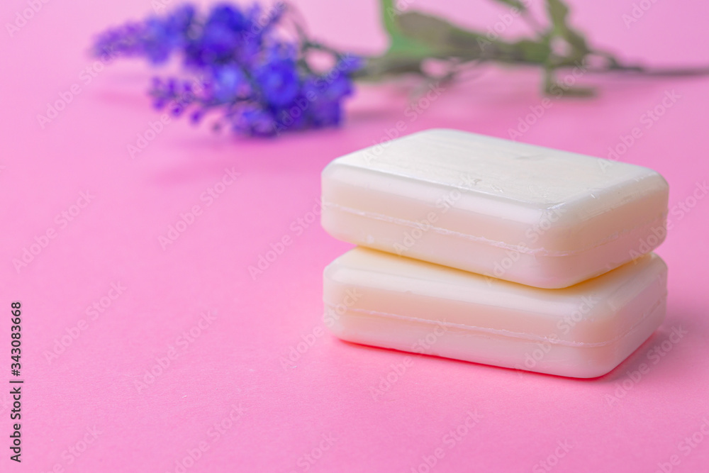 Bars of handmade soap with flowers on the table, close up