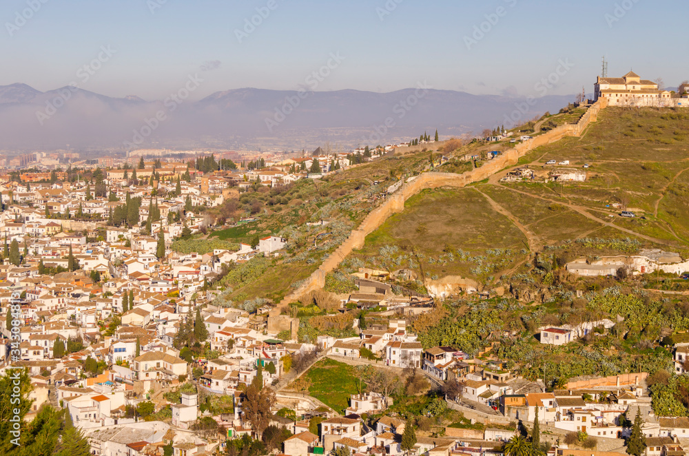 View of the Alhambra and the Generalife and the city of Granada from the viewpoint of the Silla del Moro at sunrise.