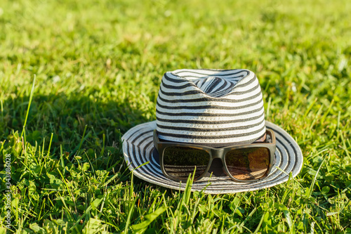 Female hat with sunglasses on the grass outdoors