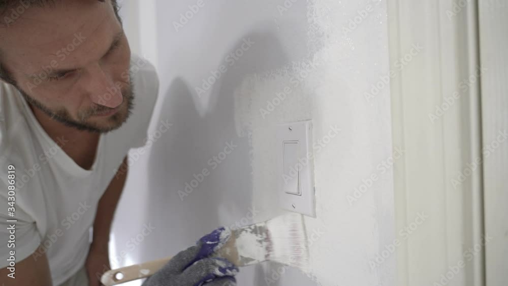 Close up of painter hands with gloves painting the wall edge with brush. Close up of painter hands with gloves painting the wall edge with brush.