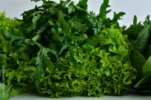juicy fresh spinach, arugula ,Lettuce salad on a white background.Fresh Organic Raw Greens. vegan, vegetarian concept.Spring avitaminosis.ingredients for detox smoothie
