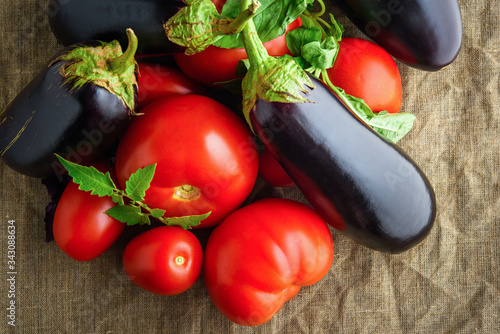 Summer vegetables: fresh red tomatoes and eggplants, top view