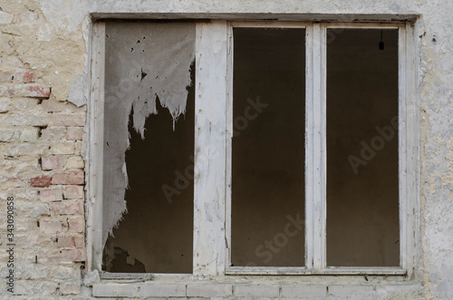 abandoned old window with torn curtains