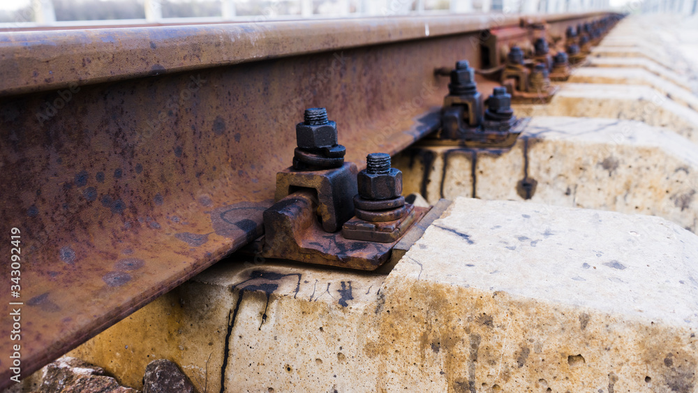 Railway rail, beams, and bolts with reinforcement close up. Railway track
