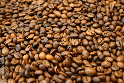 Brown roated coffee beans background, closeup photo