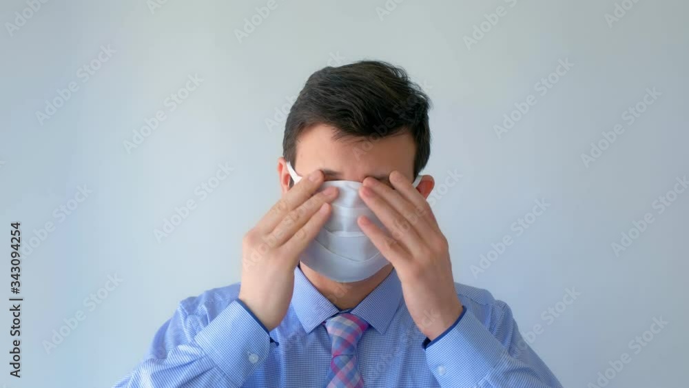 Man is putting on protective medical mask and glasses on face, coronavirus pandemic. Man office worker on white background. Worldwide global COVID-19 epidemic. Fighting with 2019-ncov infection. Man is putting on protective medical mask and glasses on face, coronavirus pandemic. Man office worker on white background. Worldwide global COVID-19 epidemic. Fighting with 2019-ncov infection.