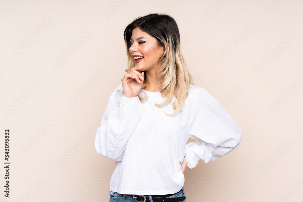 Teenager girl isolated on beige background looking to the side Teenager girl isolated on beige background looking to the side