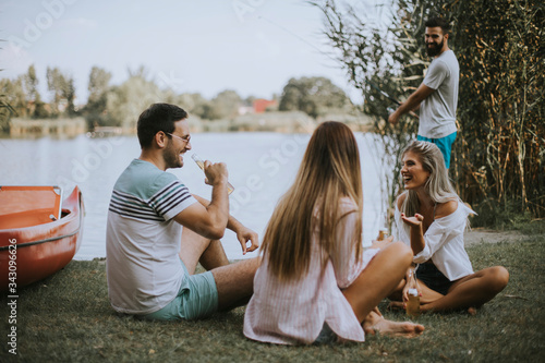 Carta da parati Group of young friends enjoying the nature on the lakeside