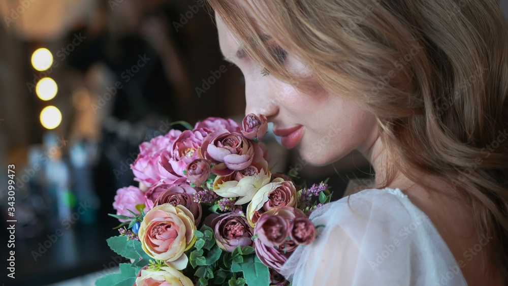 Naklejka premium Beautiful young girl with a bouquet of flowers