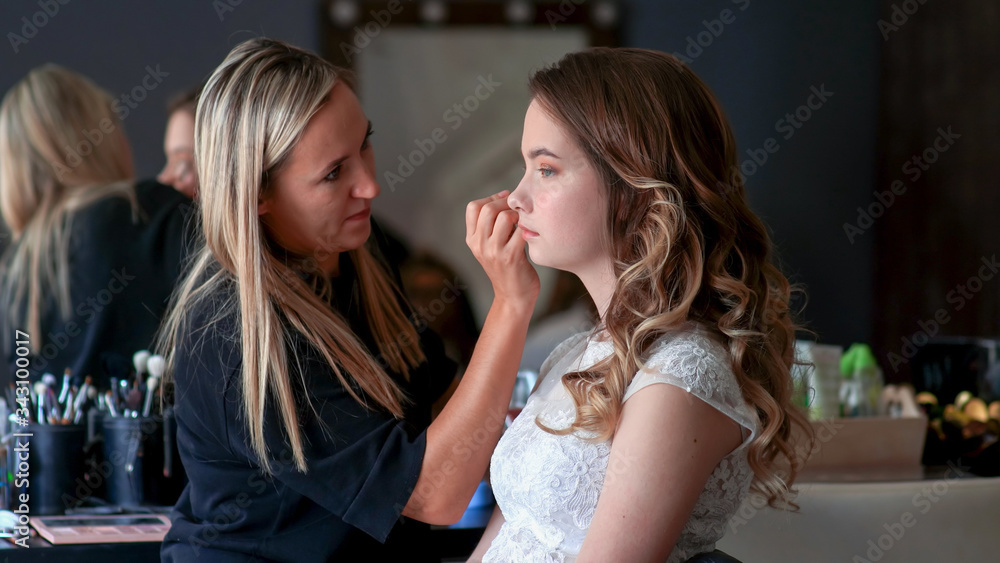 Makeup artist paints the eyes of a girl model Makeup artist paints the eyes of a girl model
