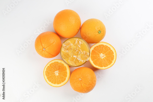 Fototapeta Naklejka Na Ścianę i Meble -  Fresh yellow orange juice in glass with whole sliced orange fruit and ice cube on white background