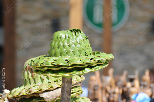 green straw hats on a stick, for sale