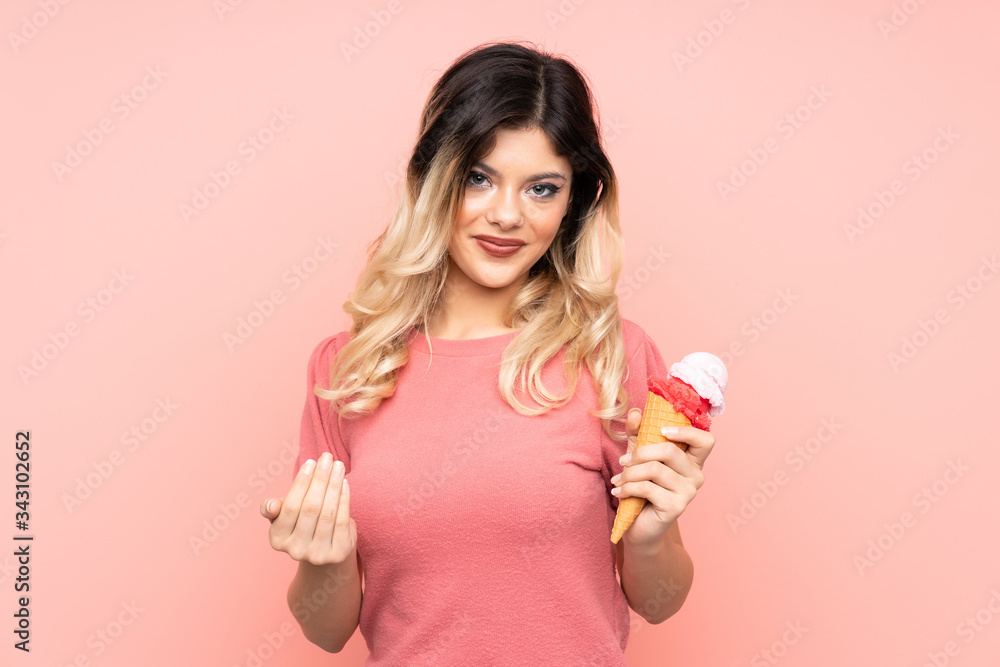 Teenager girl holding a cornet ice cream isolated on pink background inviting to come with hand. Happy that you came Teenager girl holding a cornet ice cream isolated on pink background inviting to come with hand. Happy that you came