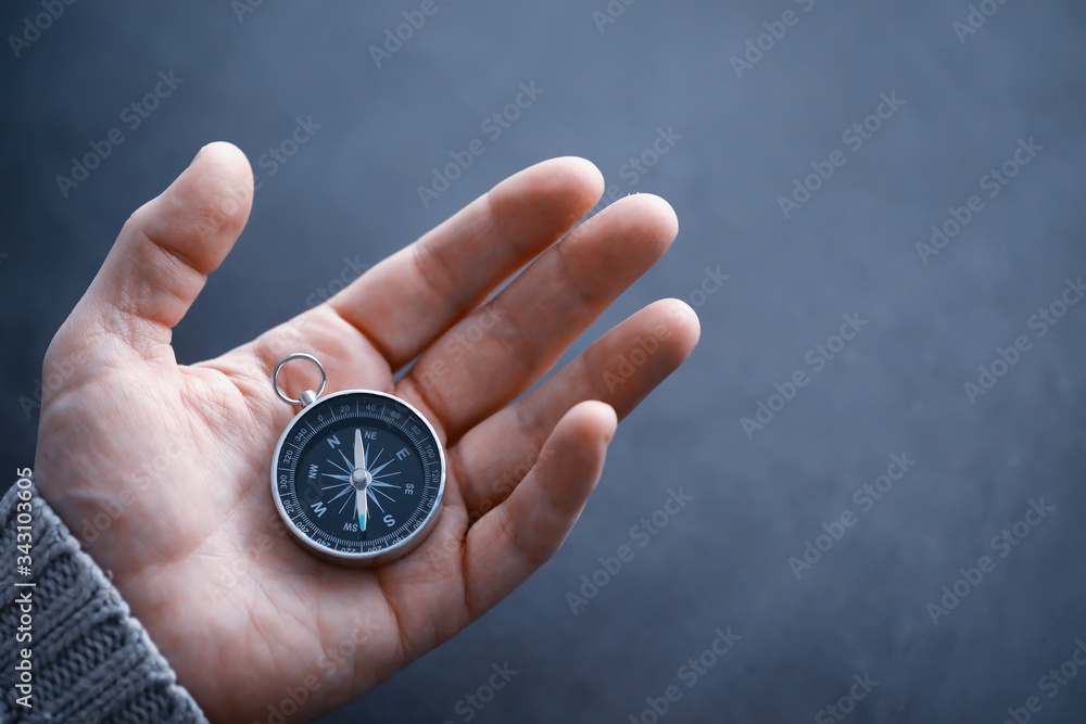 Travel concept. Magnetic compass in the hand. Retro navigator in hand a map and airplane background. Adventure Background.
