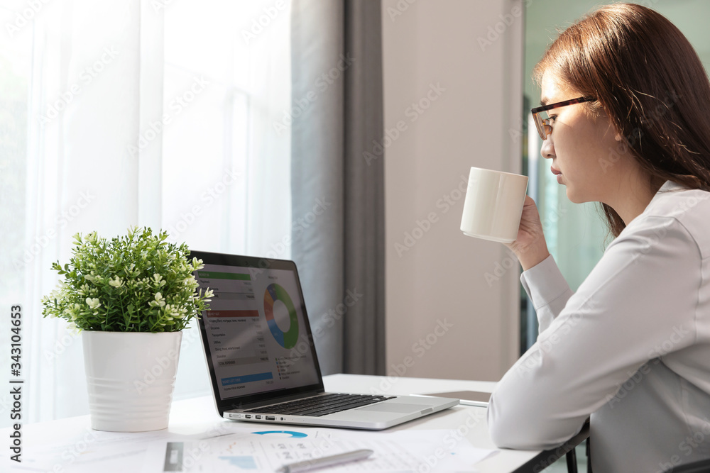 Women using laptop and drink coffee in home office, Young woman is making plans for the business. Women using laptop and drink coffee in home office, Young woman is making plans for the business.