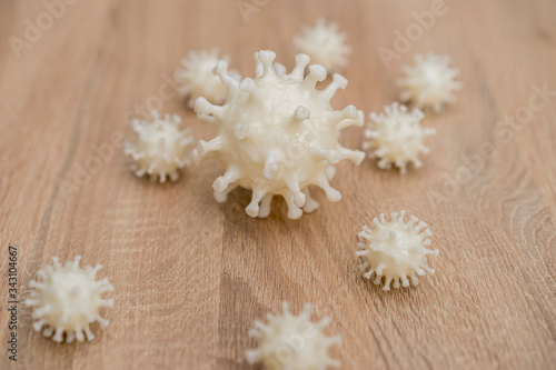 covid19, 3d printed representation of the virus on a wooden surface. home security and protection against viruses