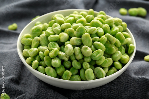 Green Broad Beans in a white bowl. healthy food photo