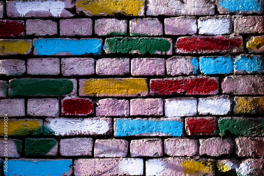 Fototapeta premium Wall with colored bricks. Old wall with painted bricks. Textured colorful background