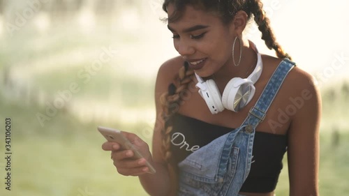 Girl using smartphone outdoor. Close-up. Generation z in hipster outfit