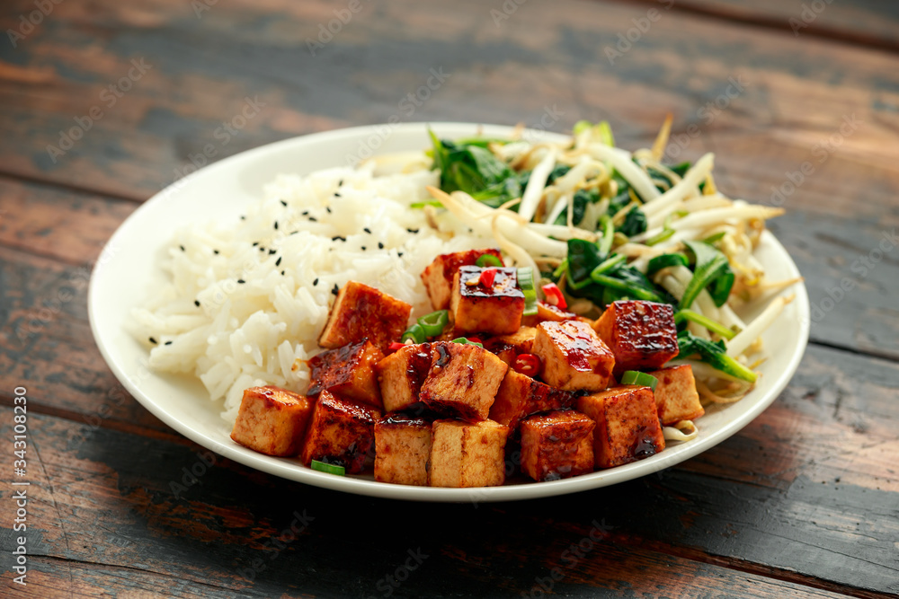 Fried Asian tofu in sweet chilli glaze served with rice, steamed spinach and beansprouts. Vegetable healthy food Fried Asian tofu in sweet chilli glaze served with rice, steamed spinach and beansprouts. Vegetable healthy food