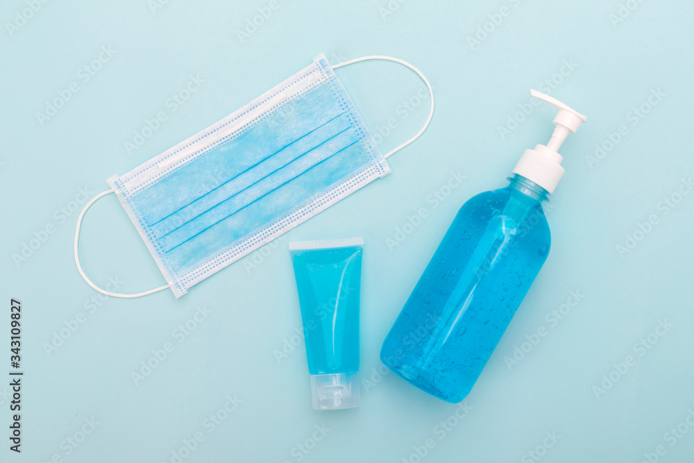 Medical mask and hand sanitizer gel on blue background Medical mask and hand sanitizer gel on blue background