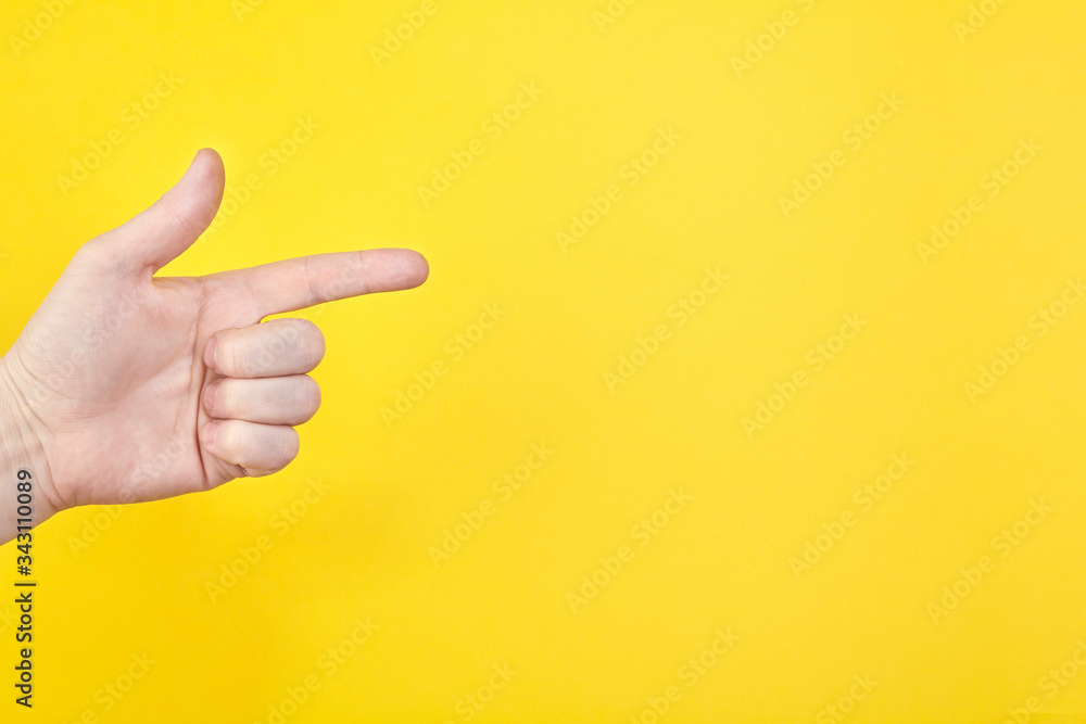 Hand show gesture on an isolated yellow background in studio
