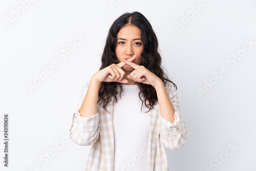 Mixed race woman over isolated white background showing a sign of silence gesture