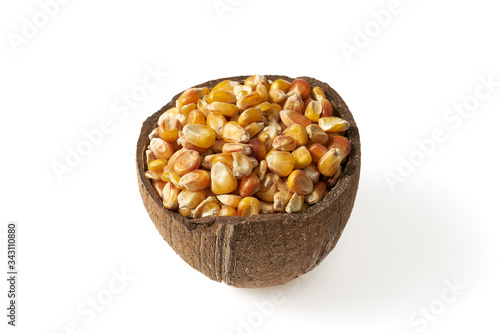 Ziarna kukurydzy w małych miseczkach z kokosa na białym tle