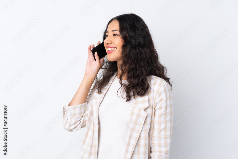 Mixed race woman over isolated white background keeping a conversation with the mobile phone Mixed race woman over isolated white background keeping a conversation with the mobile phone