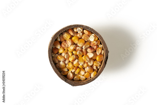 Ziarna kukurydzy w małych miseczkach z kokosa na białym tle