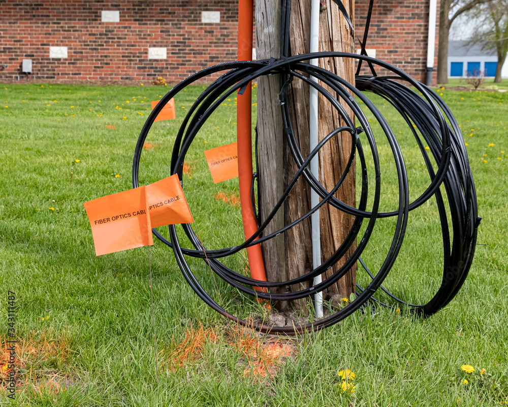 Foto de Fiber optic cable, orange marking flags and utility pole