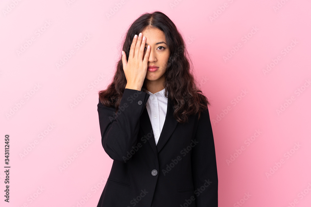 Mixed race business woman over isolated pink background covering a eye by hand Mixed race business woman over isolated pink background covering a eye by hand