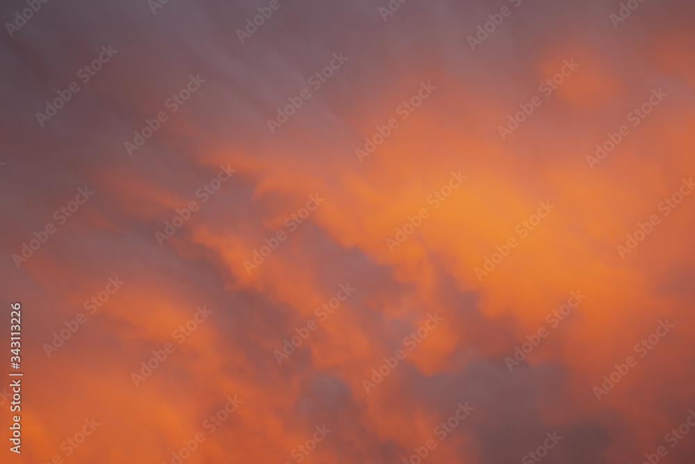 Soft and Vibrant bright orange purple and blue sky full of clouds at sunset to be used as a background with copy space