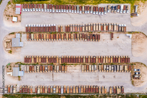 Rows of Military trucks parked at a logistics Army base, Top down aerial image.