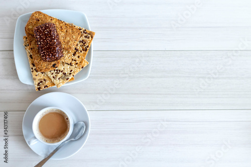 Fotografie Cup of coffee with cereal cookies on a white wooden table