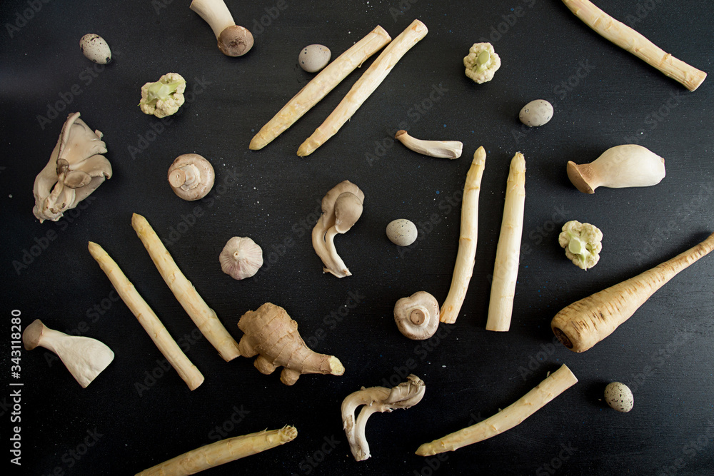 Raw ingredients set for cooking on black background: white asparagus, mushrooms, eggs, cauliflower. Flat lay. Overhead. Top view. Raw ingredients set for cooking on black background: white asparagus, mushrooms, eggs, cauliflower. Flat lay. Overhead. Top view.