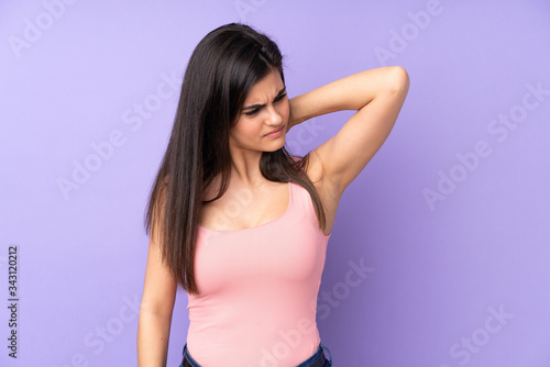 Young woman over isolated purple background with neckache
