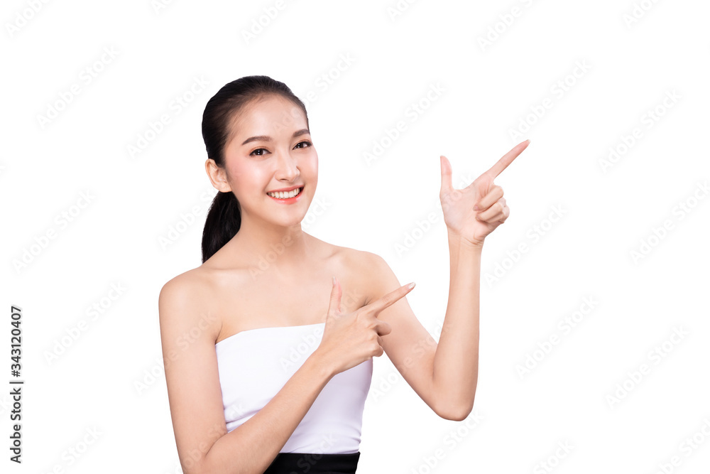 Portrait of Asian beautiful young woman pointing both hand with finger on upper side with smile face. The girl standing and looking at camera in studio for beauty advertisement and presentation. Portrait of Asian beautiful young woman pointing both hand with finger on upper side with smile face. The girl standing and looking at camera in studio for beauty advertisement and presentation.